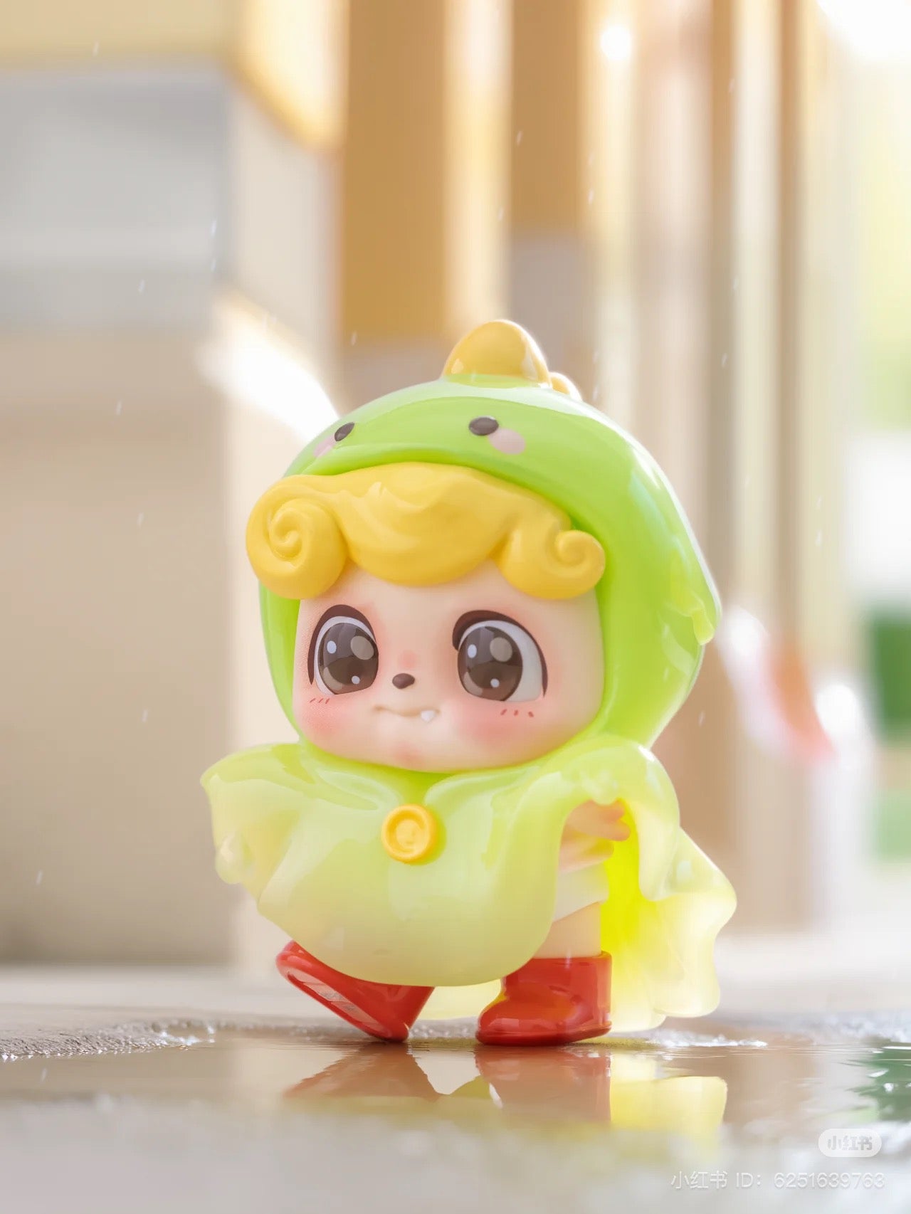 Be Your Q Baby Blind Box Series toy figurine in a raincoat, featuring a child-like cartoon face. Preorder for Aug 2024.