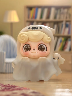 Be Your Q Baby Blind Box Series toy ghost figurine displayed in front of a bookshelf. Preorder for Aug 2024.