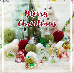 A group of small glass figurines and a green Christmas tree with stars, part of the Christmas Ghost Set by Ghost John.