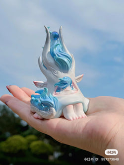 A hand holding a small unicorn statue by 1001 Moons - Preorder, Feb 2024.