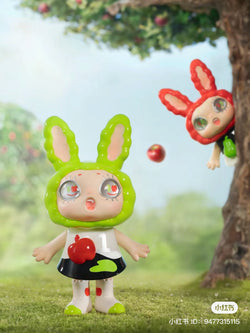 Toy doll figurine with bunny ears, red apple balloon, and cartoon character.