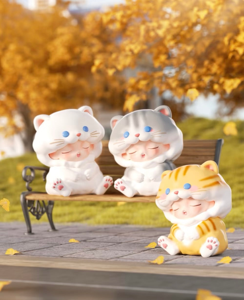 YUMO Stay With You Blind Box Series featuring a white cat doll with blue eyes among a group of whimsical toy figures on a bench.