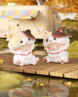 YUMO Stay With You Blind Box Series featuring two small ceramic cat figurines on a wooden platform, part of a collectible toy set.