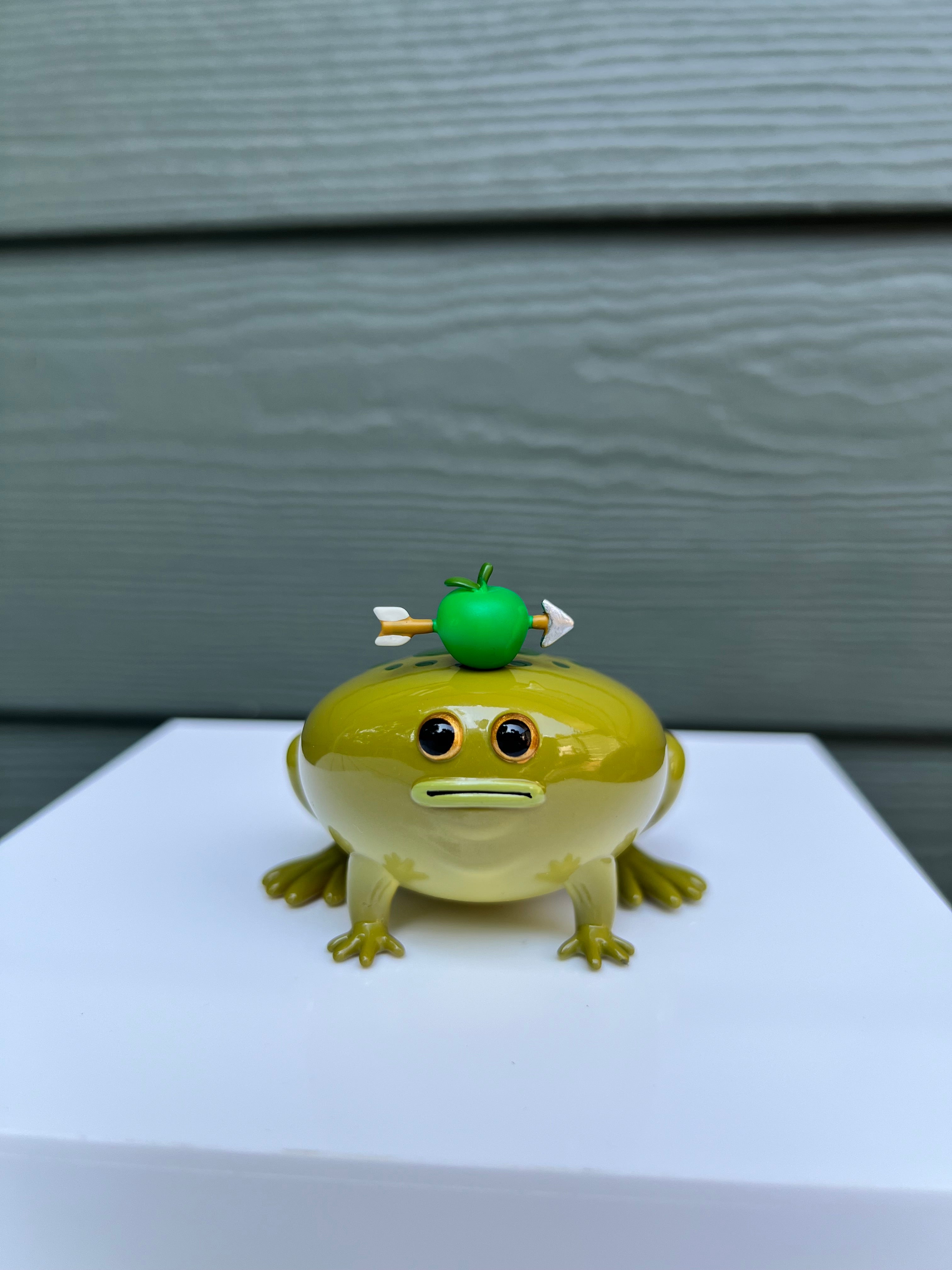 Frod by Sad Salesman: a soft vinyl toy of a green frog with a green apple on its head, limited to 100 pieces, size 2.5” x 3”.