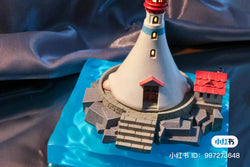 A miniature Notte Lighthouse model on an island base, with a pressure-sensitive lamp set and floor cover. From Strangecat Toys.