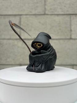 A toy figure of a lone reaper with a scythe, gold skull, and hood, limited edition resin, 9 tall. From Grim Ideas - Lone Reaper XL Gold Chrome by Riser.