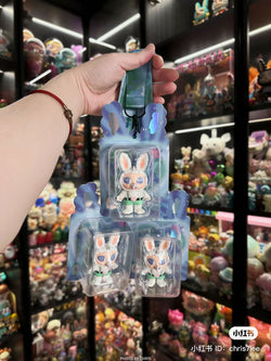 A hand holds Agan Agan-65% bang bang bang toy in plastic packaging. Reflects Strangecat Toys' blind box and art toy store essence.