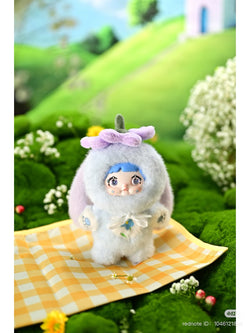 Nommi Garden Rabbit Plush Blind Box toy displayed on a blanket, featuring a doll in a bunny outfit, part of a collectible series.