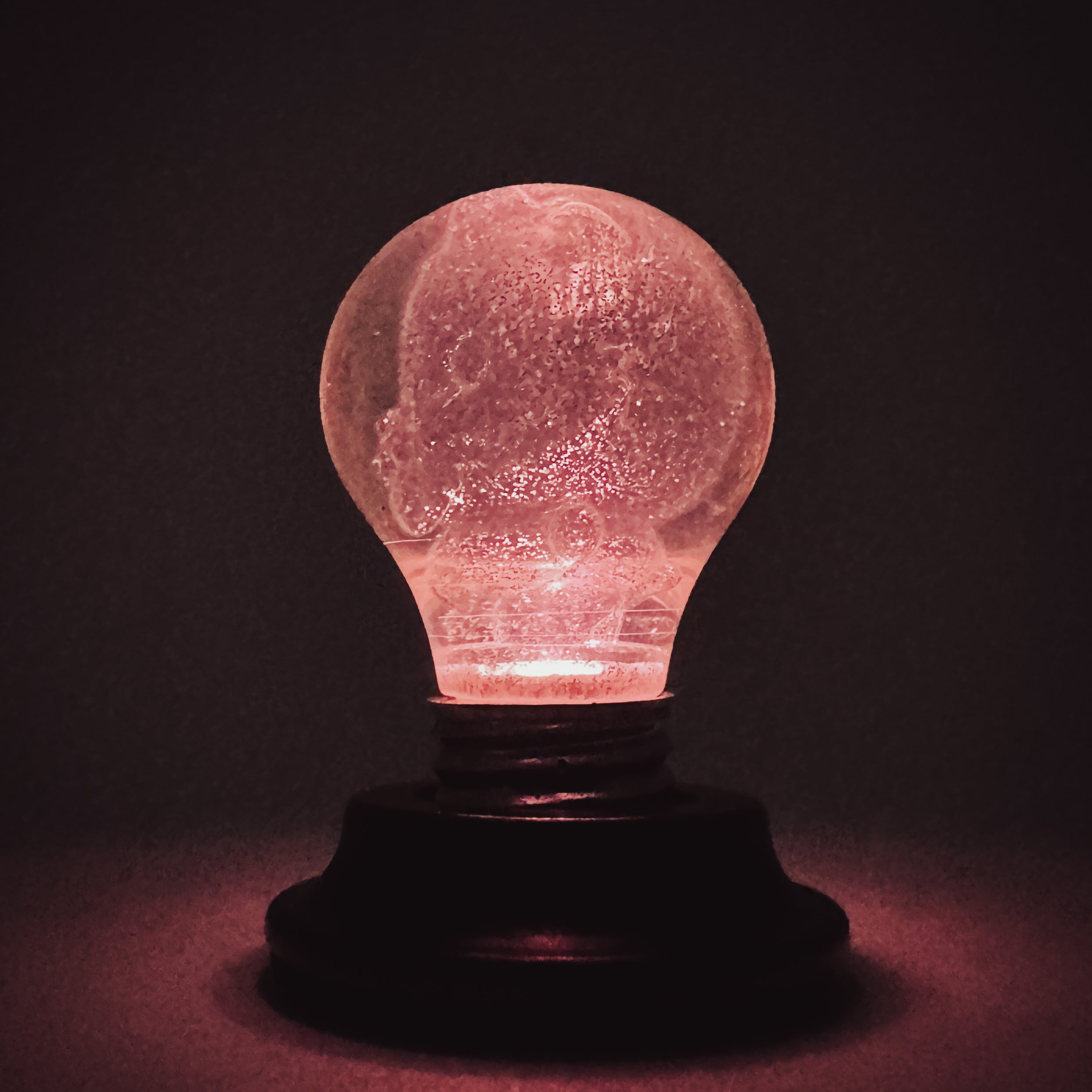 Hello World - HOLOGRAMPA BLB by JFO, a unique light bulb design featuring a face carving, blending art and functionality.