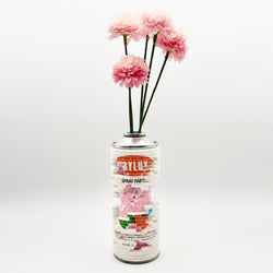 Hello World - BRIX CAN VASE by JFO features pink artificial flowers in a can, highlighting a unique floral design aesthetic.