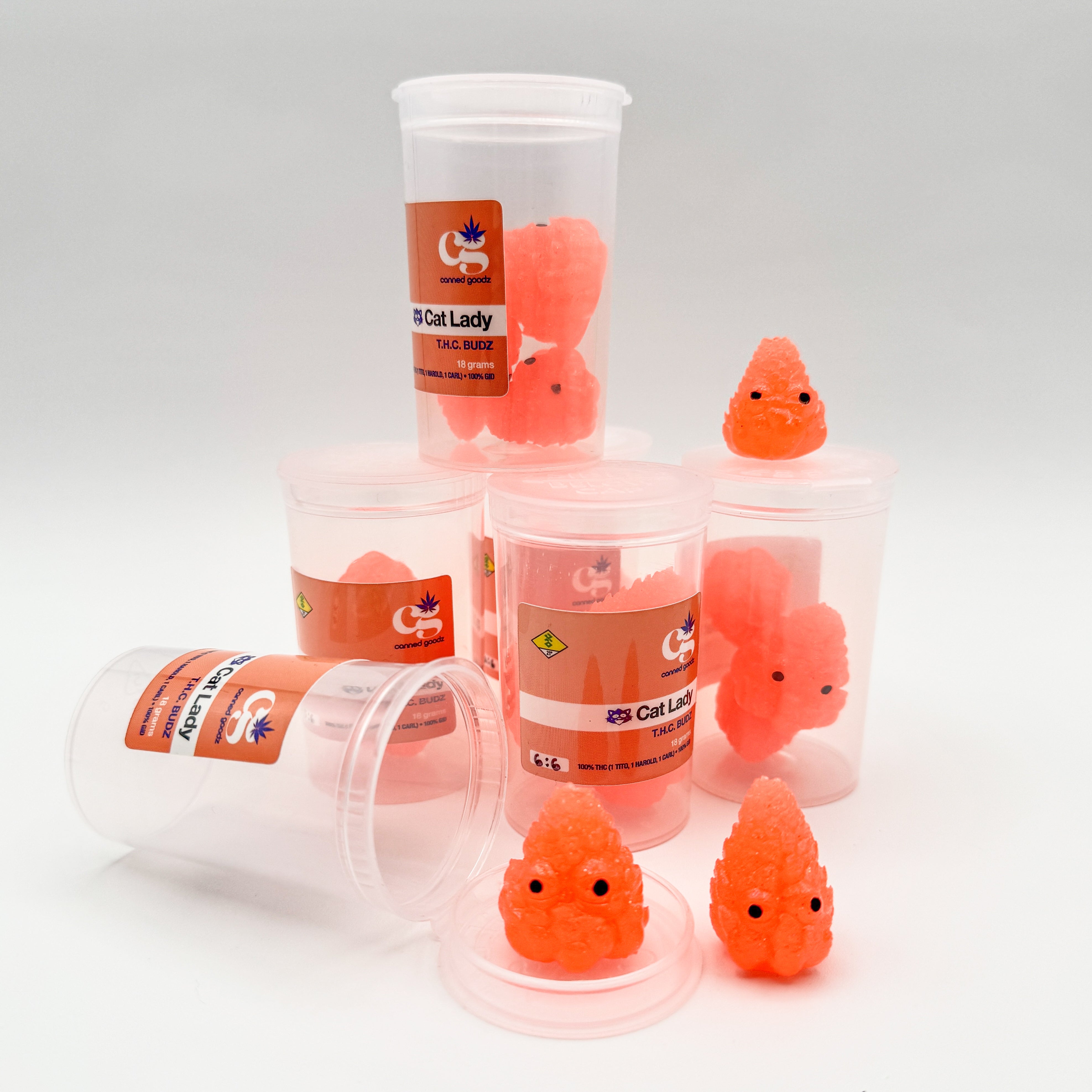 Hello World - THC BUDZ by JFO: Plastic containers with whimsical orange objects atop, featuring black eyes, part of Strangecat Toys' blind box art collection.