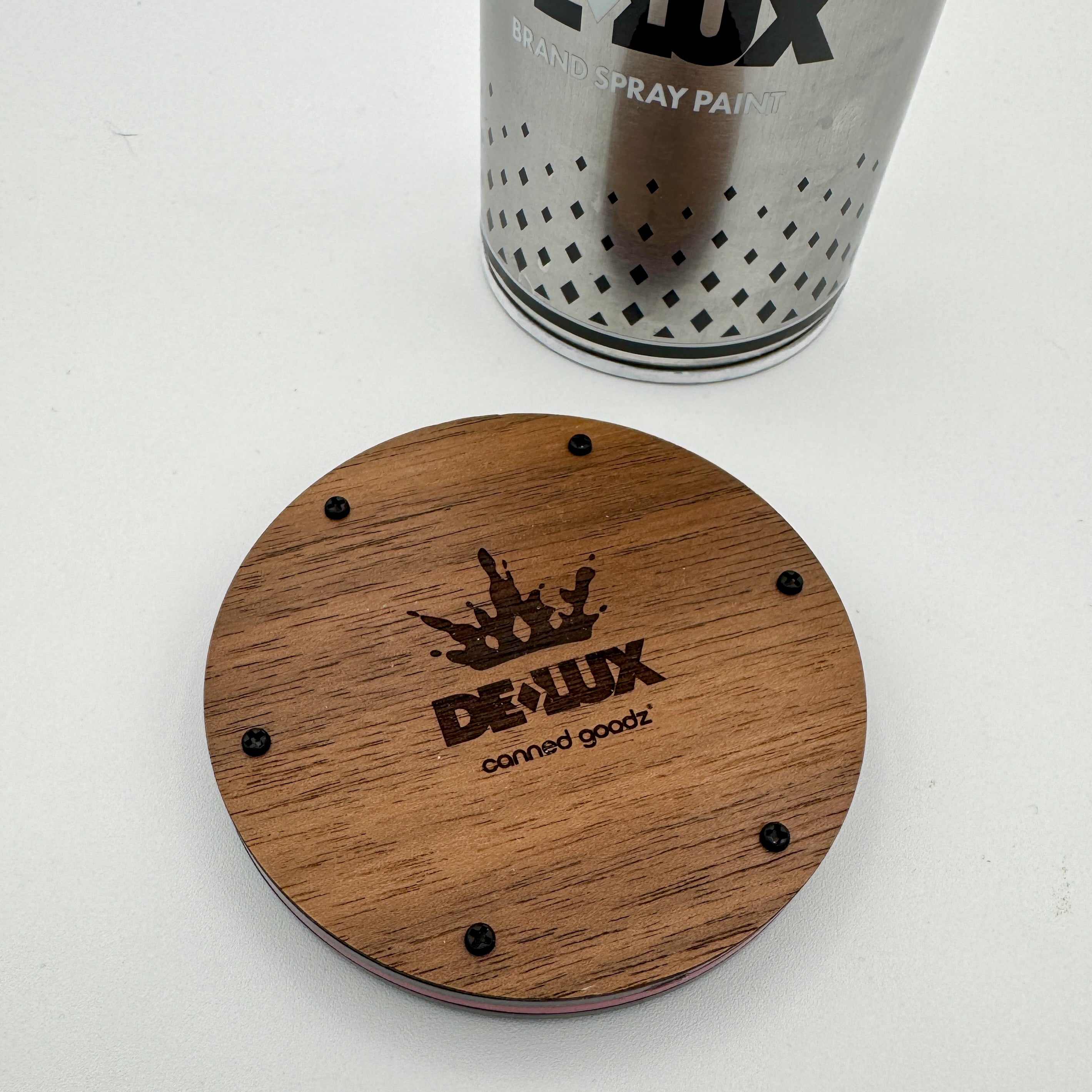 Hello World - DE-LUX CAN by JFO next to a round wooden coaster, showcasing a spray paint can design, aligning with Strangecat Toys' art toy collection.