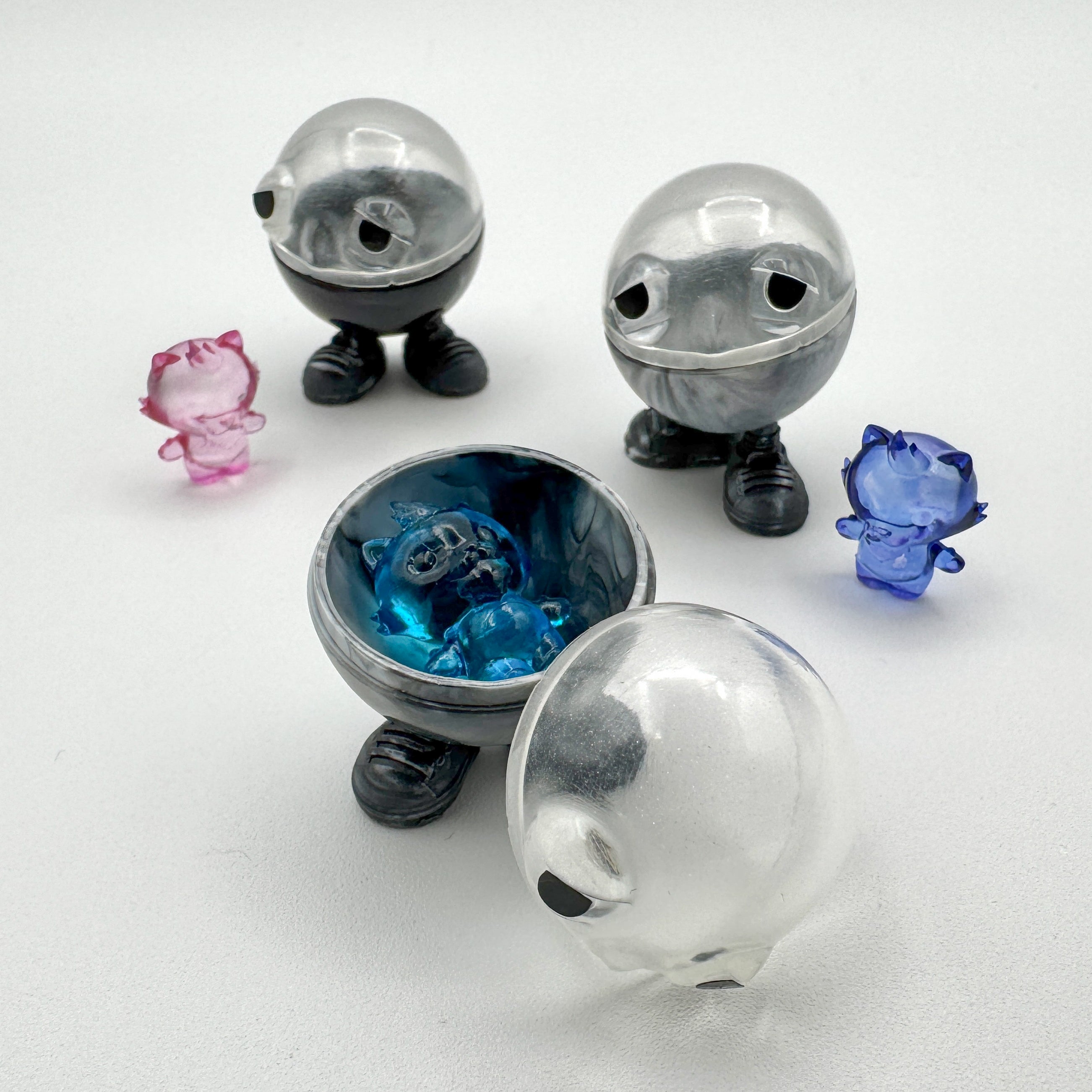 Hello World - MR. CAPS + GRANDPA by JFO: A unique art toy set featuring various whimsical plastic figures, including a clear ball and character pieces.