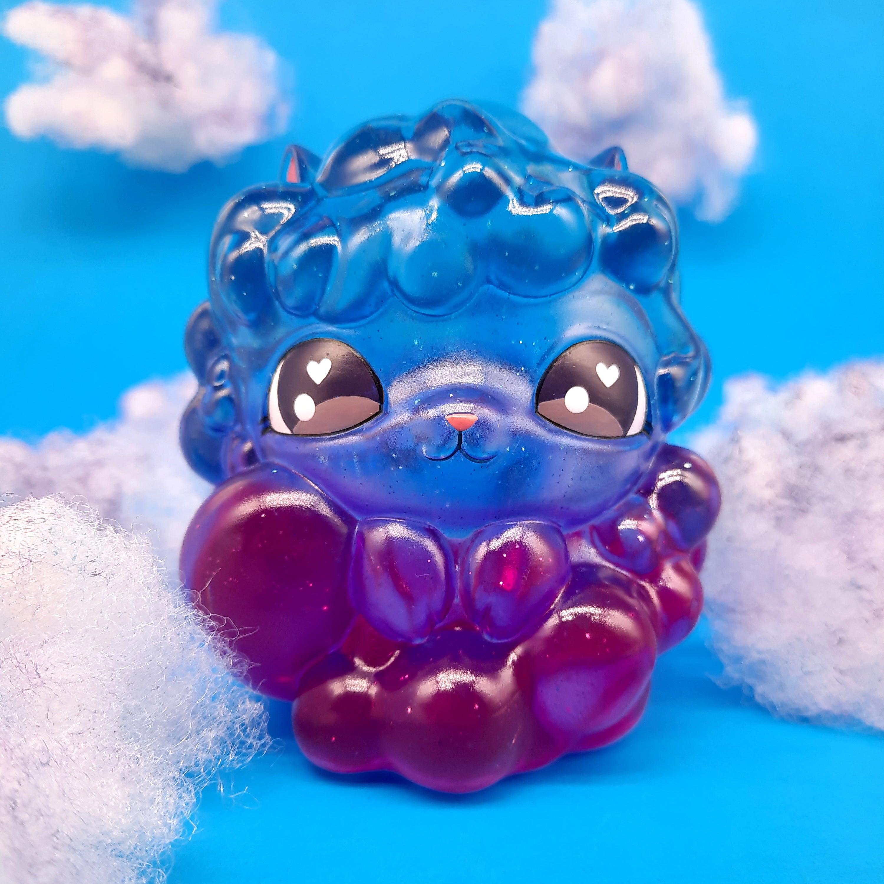 Kumo Kitty - Nightfall by The Bots: A whimsical resin cloud cat figurine, 4 inches tall, featuring a blue and purple design with cartoon eyes and heart details.