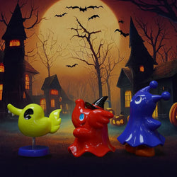 Toy figures including Greenie & Elfie in front of a haunted house, with a blue pointed hat and red statue with a black hat.