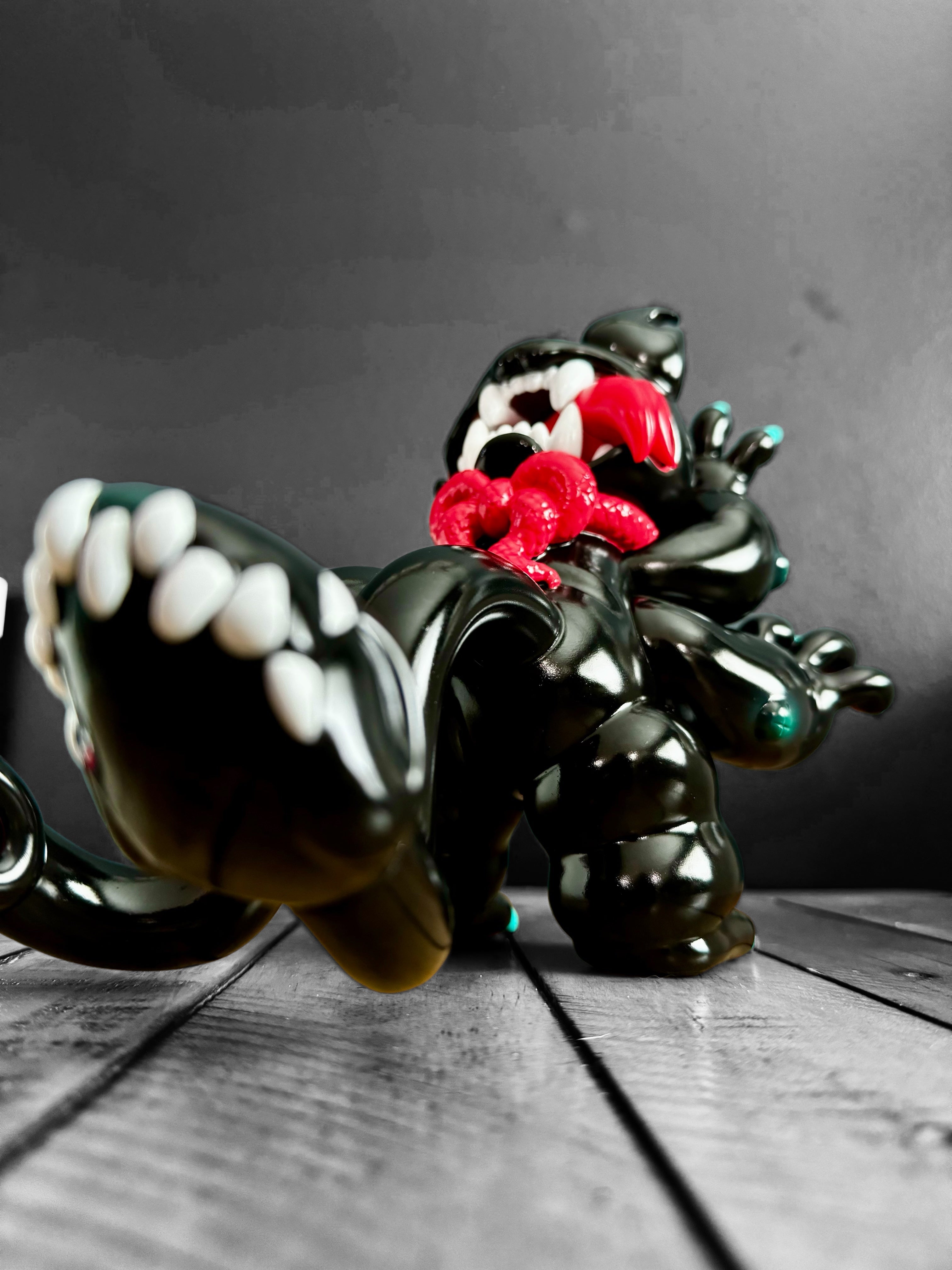 A vinyl toy of DAINIGIRUJIN Black Ver. by Grape Brain, 8 inches tall, 9.5 inches long, limited to 100pcs. Close-up of black toy with white teeth and a red snake.