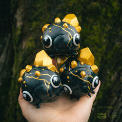 Gempod - Podsugi toy, inspired by Faunwood, features a black and gold design, held in hand, limited edition of 100 pieces.