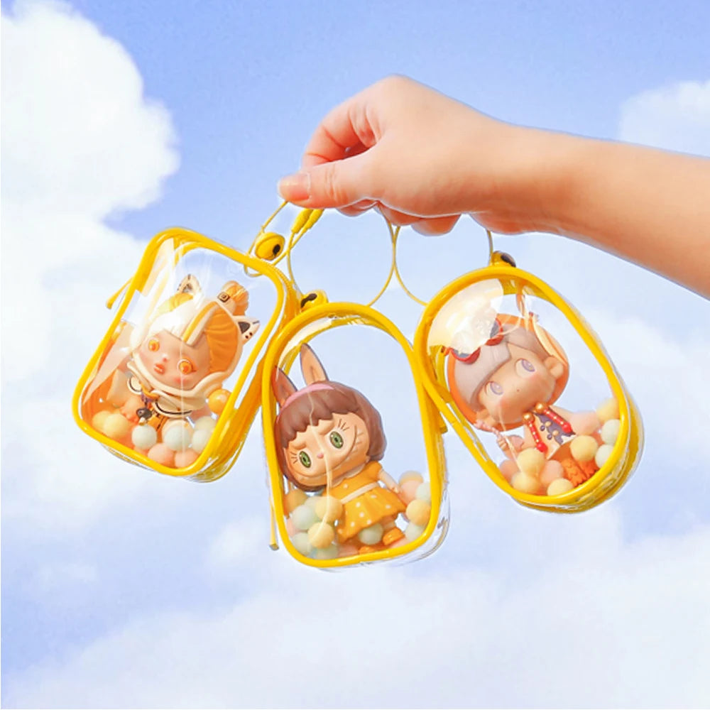 A hand holding a transparent Toy Pochette Keychain with cartoon characters inside, suitable for displaying dolls.