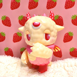 Kaiju NEMUKE Strawberry Milk toy figure of a dreamy monster with a close-up of a strawberry eye.