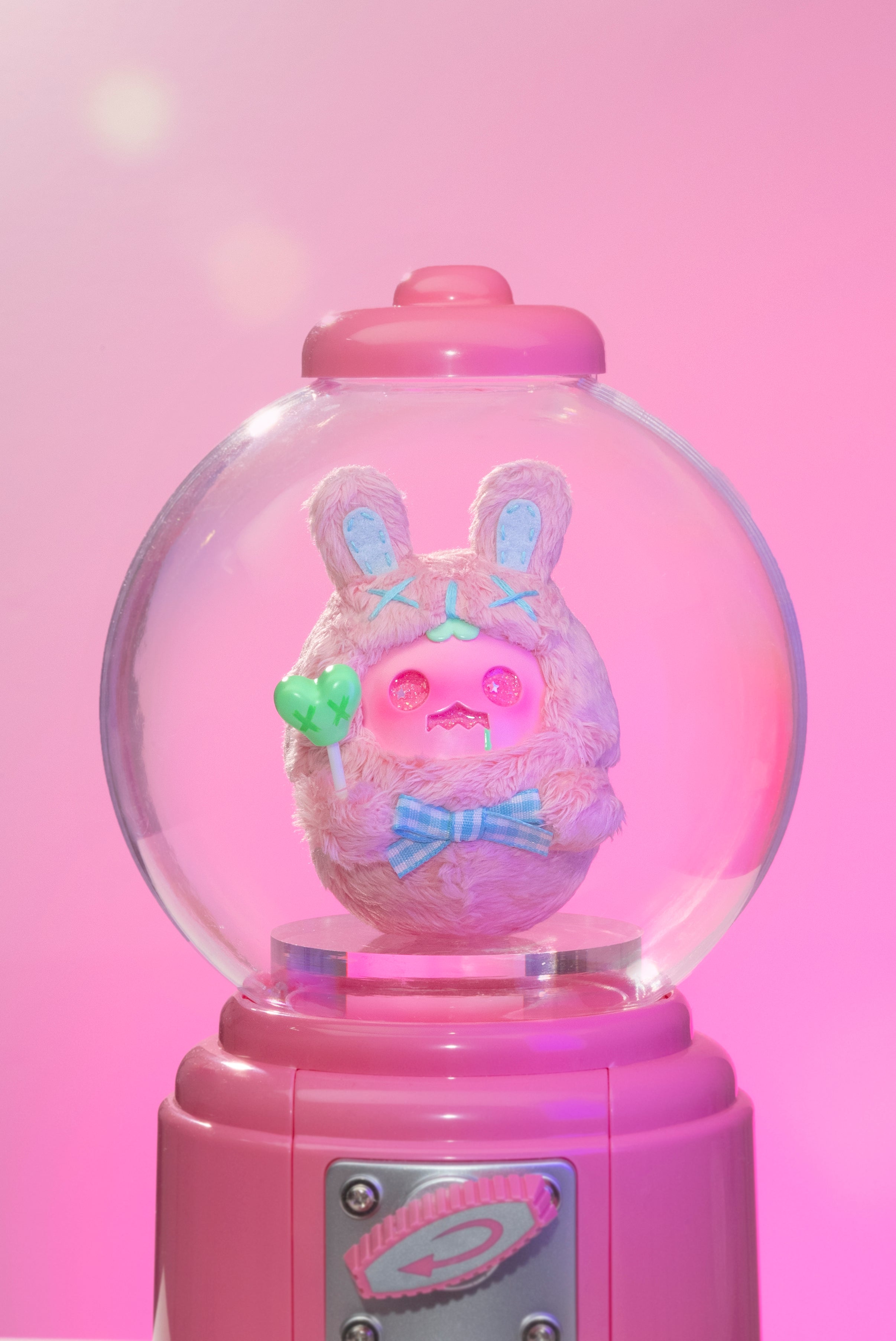 Sweet Death by Shinwoo: A pink stuffed animal encased in a glass ball, featuring a pink heart and blue bow tie.