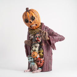 A spooky 12 tall doll figurine by Sam Heimer, featuring a pumpkin-headed ghost with various faces and masks.