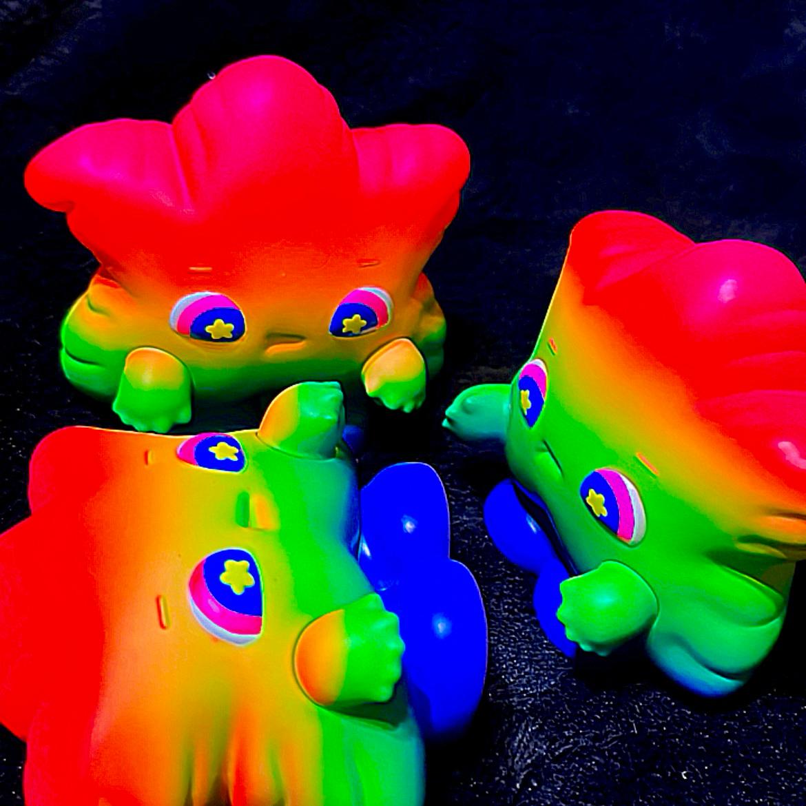 Rainbow Weee baby toy animal with rainbow face and eyes, colorful plastic toys in group.
