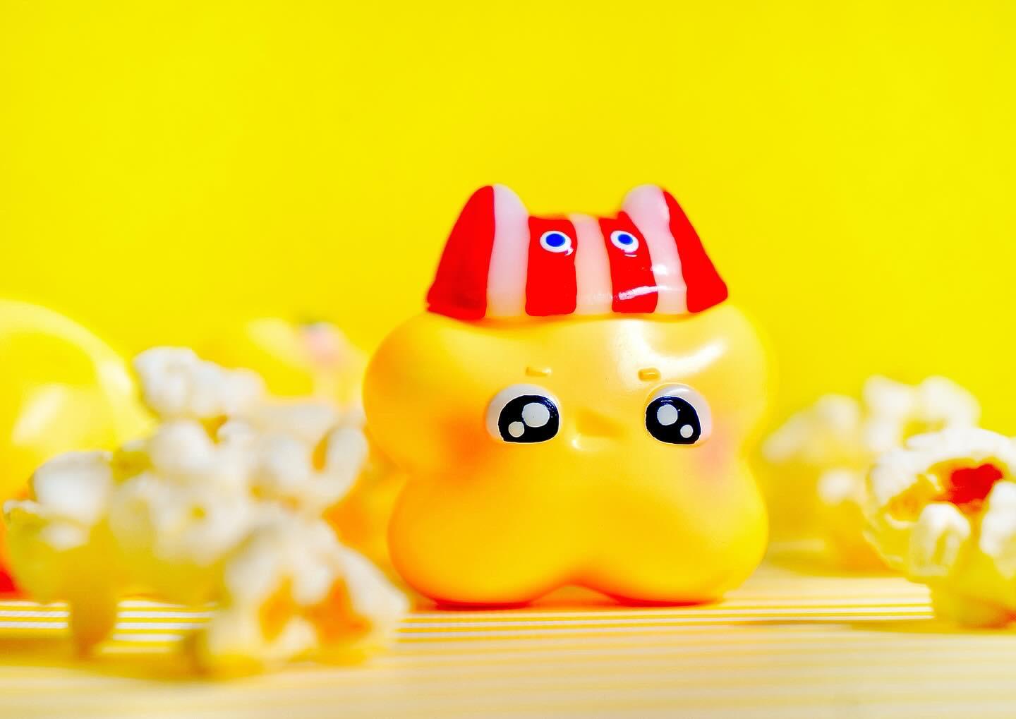 Popstar toy with red and white hat, popcorn, and candy close-up, baby toys, cartoon, animal figure, rubber ducky, and smiley details.