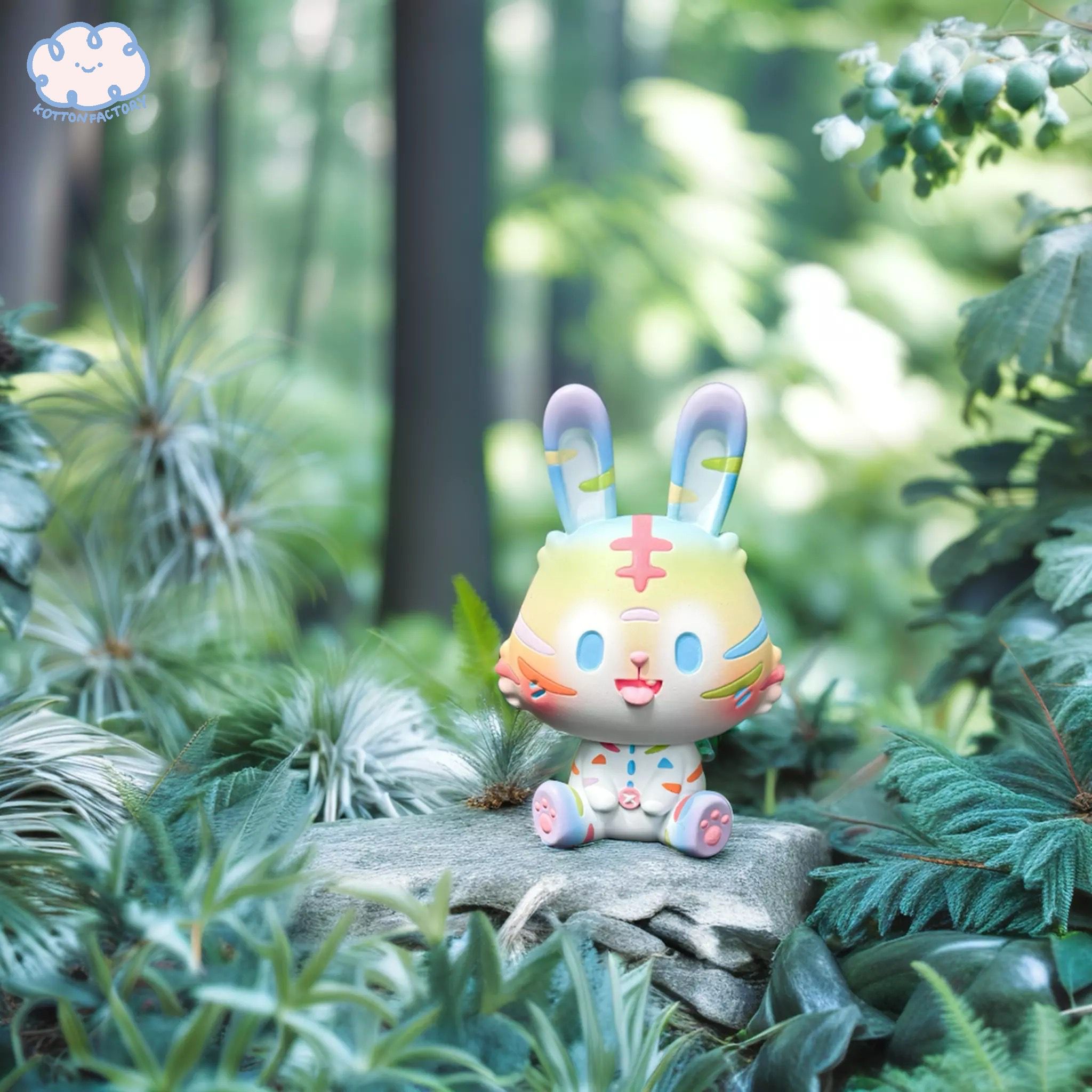 Alt text: Resin toy animal, Tiger - White & Rainbow Robin by Kotton Factory, displayed in a wooded setting. Limited edition of 100 pieces, 10cm tall.