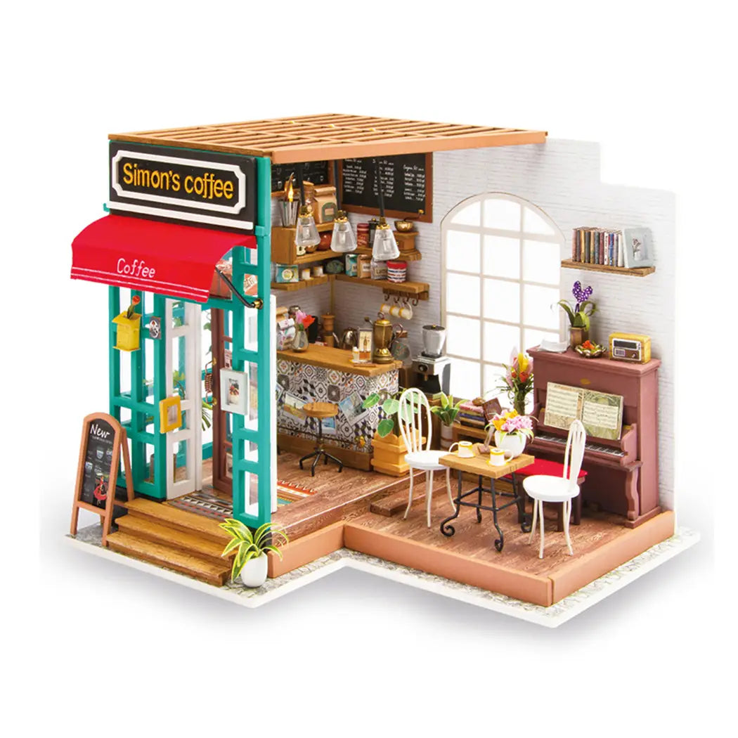 A miniature DIY coffee shop model kit by Simon, featuring a white chair, plant, window, and more. Includes LED light and assembly tools. From Strangecat Toys.