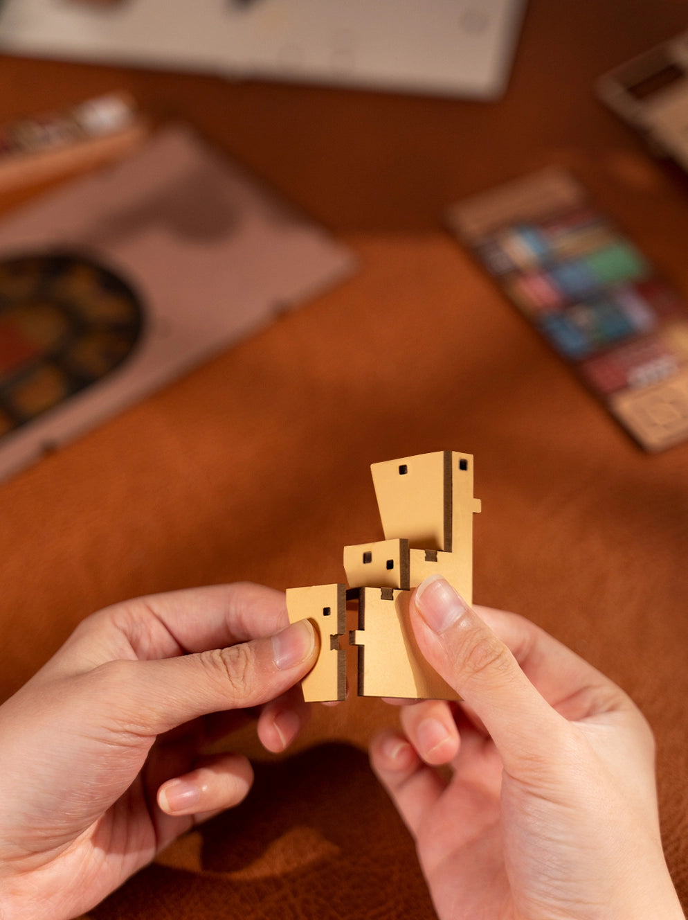 A person's hand holding a book nook kit for adults - bookstore, with a nail, indoor setting. Product includes detailed coloring instructions, batteries required. Store: Strangecat Toys - A blind box and art toy store.