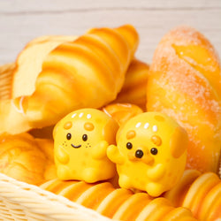 A close-up of Chubbyman & Mii Pan Cheese Bread vinyl toy with bread and toys.