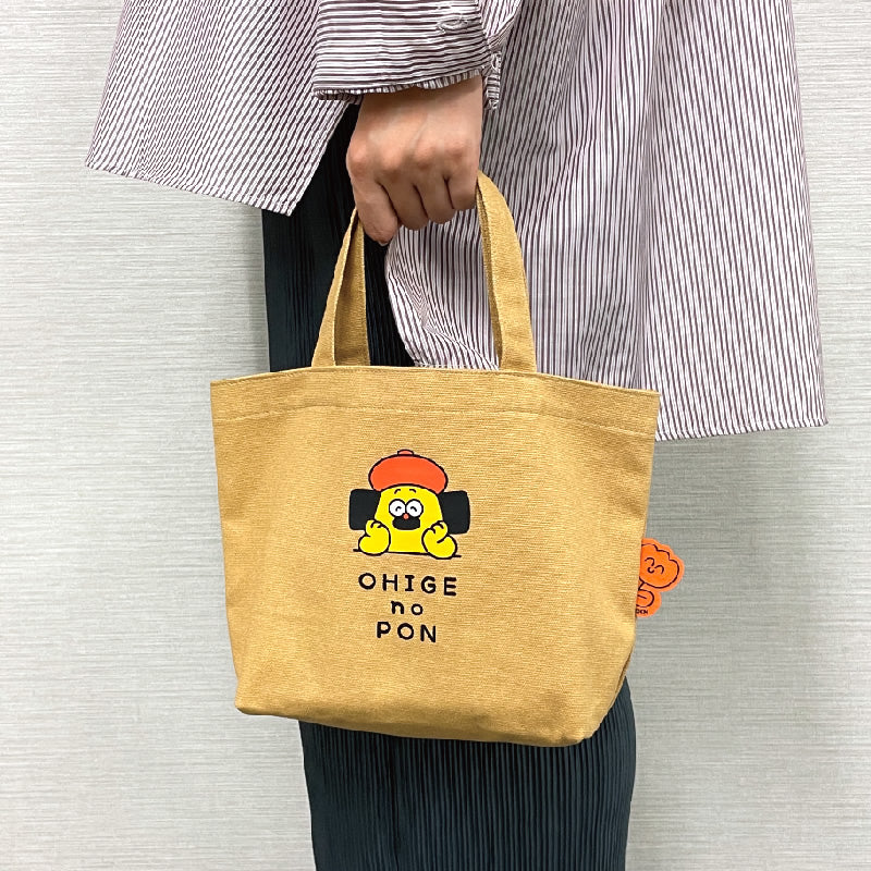 Person holding the OHIGE NO PON Mini Bag, a compact fashion accessory celebrating its 10th anniversary, popular in Japan and overseas.