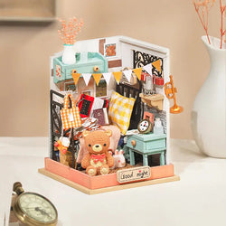 A miniature DIY bedroom kit titled Sweet Dream -Bedroom Mini Diy House, featuring a toy box with a teddy bear, clock, key, and more. Ideal for creative gifting and home decor. Dimensions: 19.6 x 11.8 x 6.8 in.