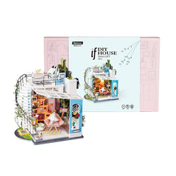 A miniature dollhouse kit featuring Dora's Loft Diy Miniature House with a spiral staircase, pink chair, and box. Experience the joy of assembling this colorful, magical candy house. Dimensions: 8.3 x 2.6 x 10.5 in.