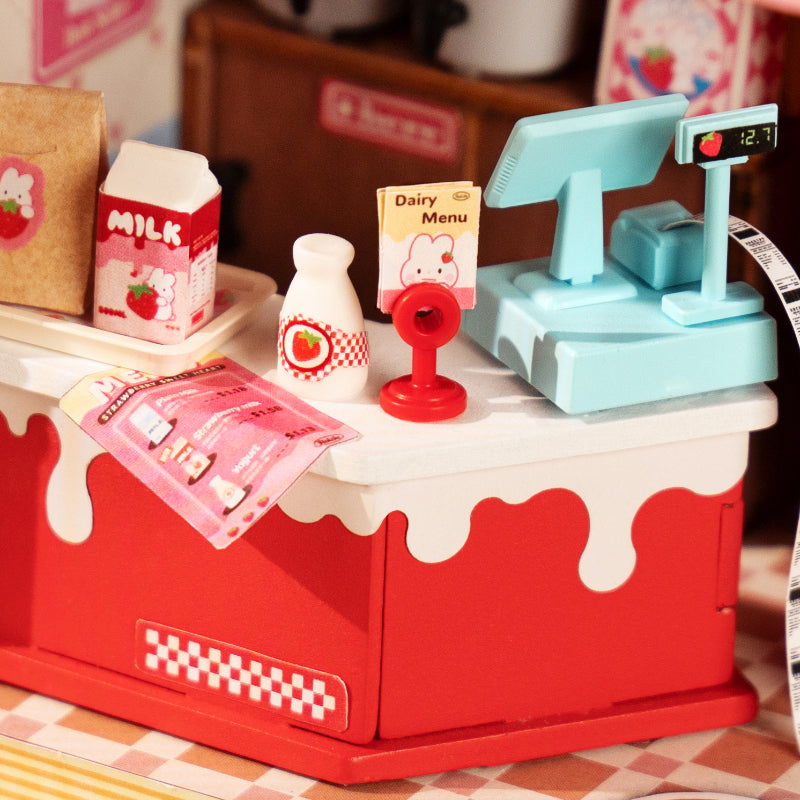 Strawberry Milk Box DIY Miniature House: A toy store-themed diorama with a cash register, milk carton, and other detailed accessories, perfect for display or pretend play.