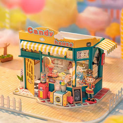 A DIY miniature house resembling a Rainbow Candy House, featuring a magical tea time scene with a bunny, drinks, snacks, and a whimsical door. Dimensions: 8.3 x 5.2 x 6.9 in.