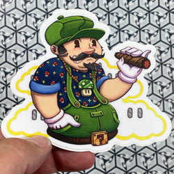 A person holding a sticker with a cartoon man holding a cigar in a drawing.