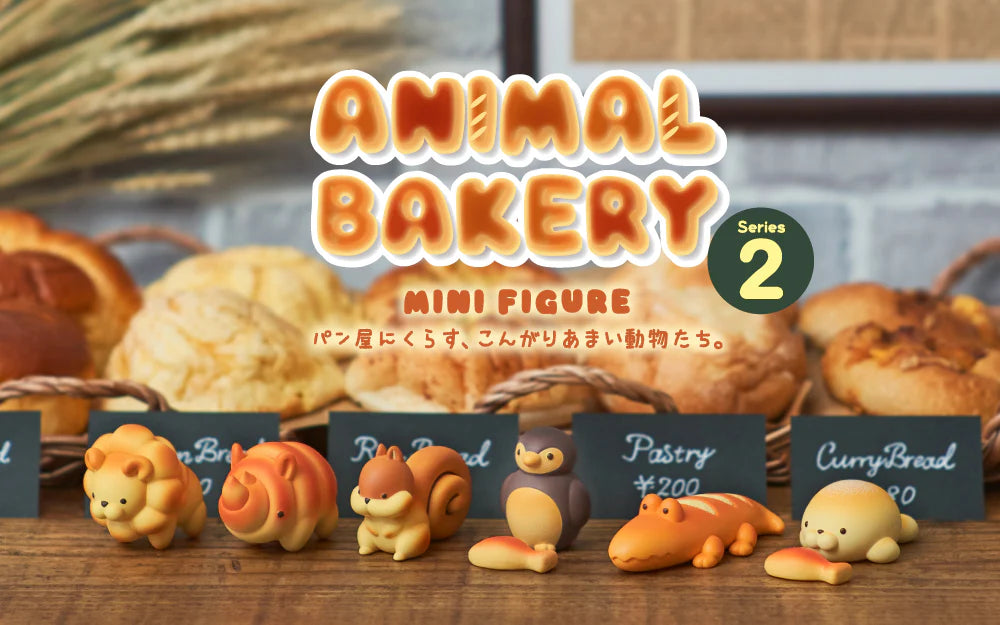 Animal Bakery Minifigure: Series 2 figurines, featuring playful bread-shaped animals, displayed on a table, highlighting the whimsical art toys from Strangecat Toys.