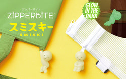 Smiski ZipperBites keychain: a small, glowing figurine with green eyes, attached to a zippered bag, designed to protect keys in your pocket or bag.