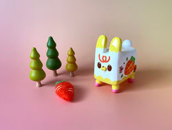 Box Rabbit by Rato Kim, a 4-inch soft vinyl toy bunny, limited to 100 pieces, shown with decorative trees.