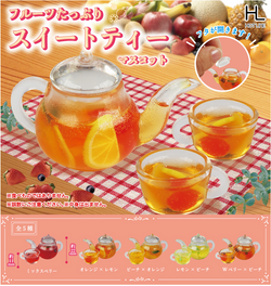 A glass teapot with fruit tea, cups, and lemon slices.