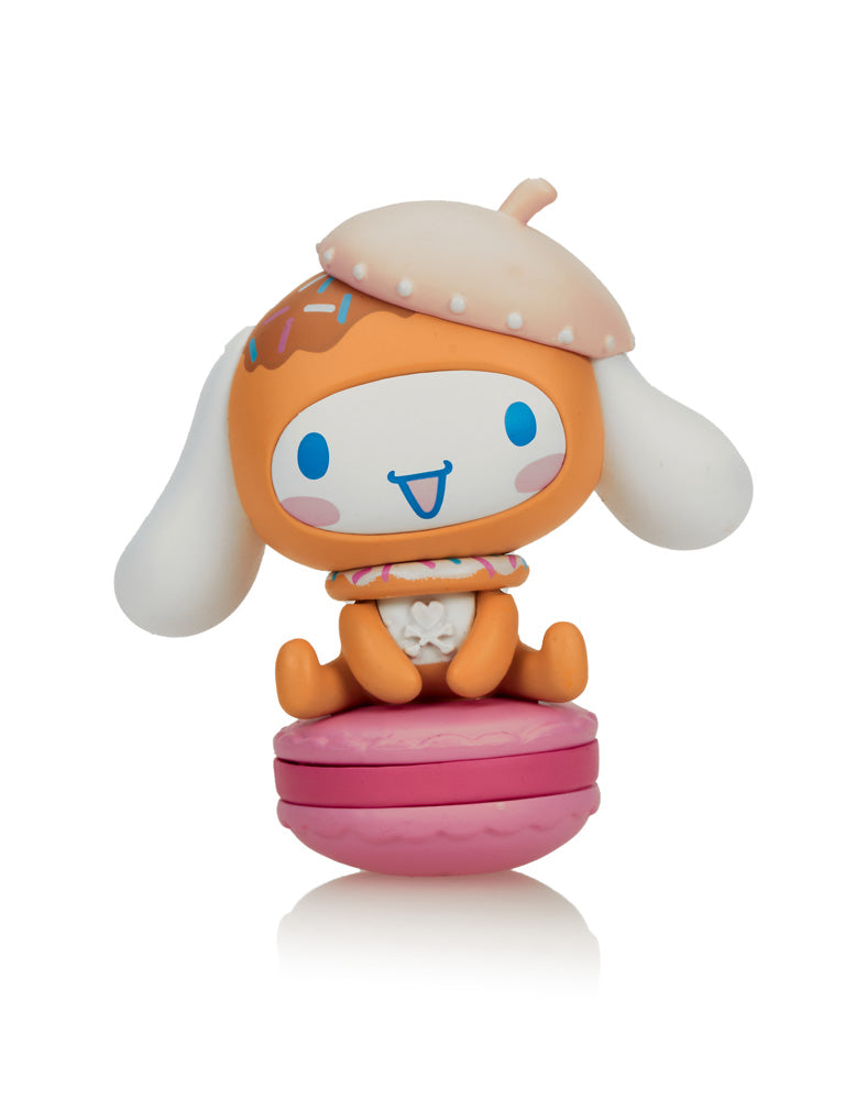 Tokidoki X Cinnamoroll Sweet Treats Blind Box, featuring a toy animal with a hat on a macaroon, part of a winter-themed character collection.