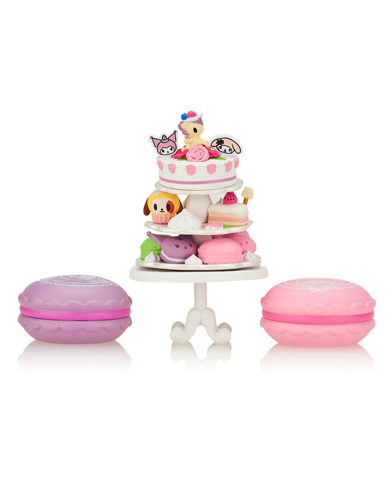 Tokidoki x Kuromi & My Melody Garden Party Blind Box Series featuring a pink cake with cartoon characters on a stand.