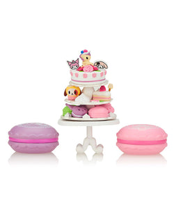 Tokidoki x Kuromi & My Melody Garden Party Blind Box Series featuring a pink cake with cartoon characters on a stand.