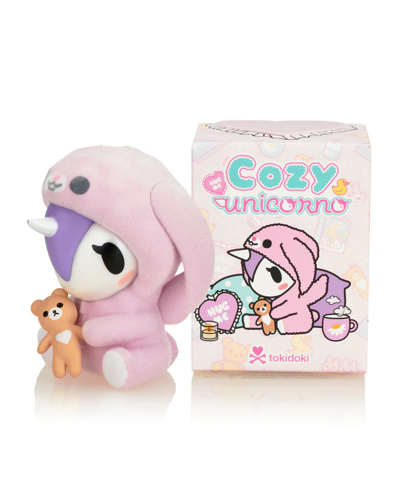 Cozy Unicorno Blind Box collectible featuring a pink unicorn doll with a teddy bear, showcasing the whimsical art toy style of Strangecat Toys.