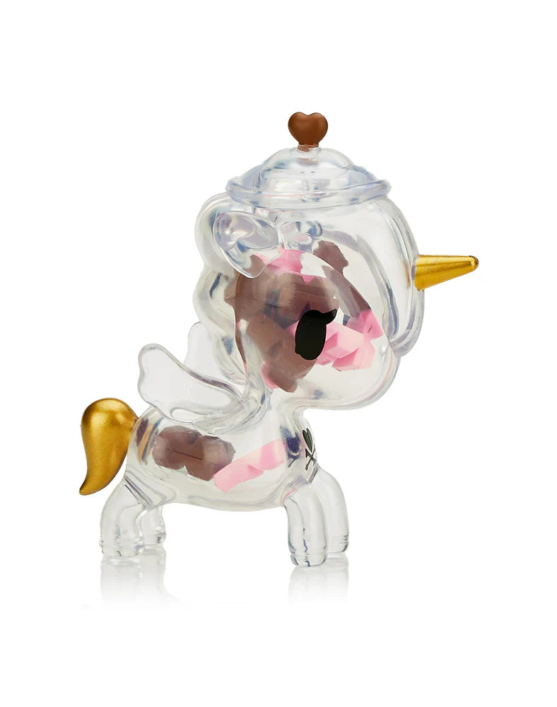 Sugar Shop Unicorno Blind Box featuring a plastic unicorn toy with a gold horn, pink ribbon, and visible candy pieces inside.