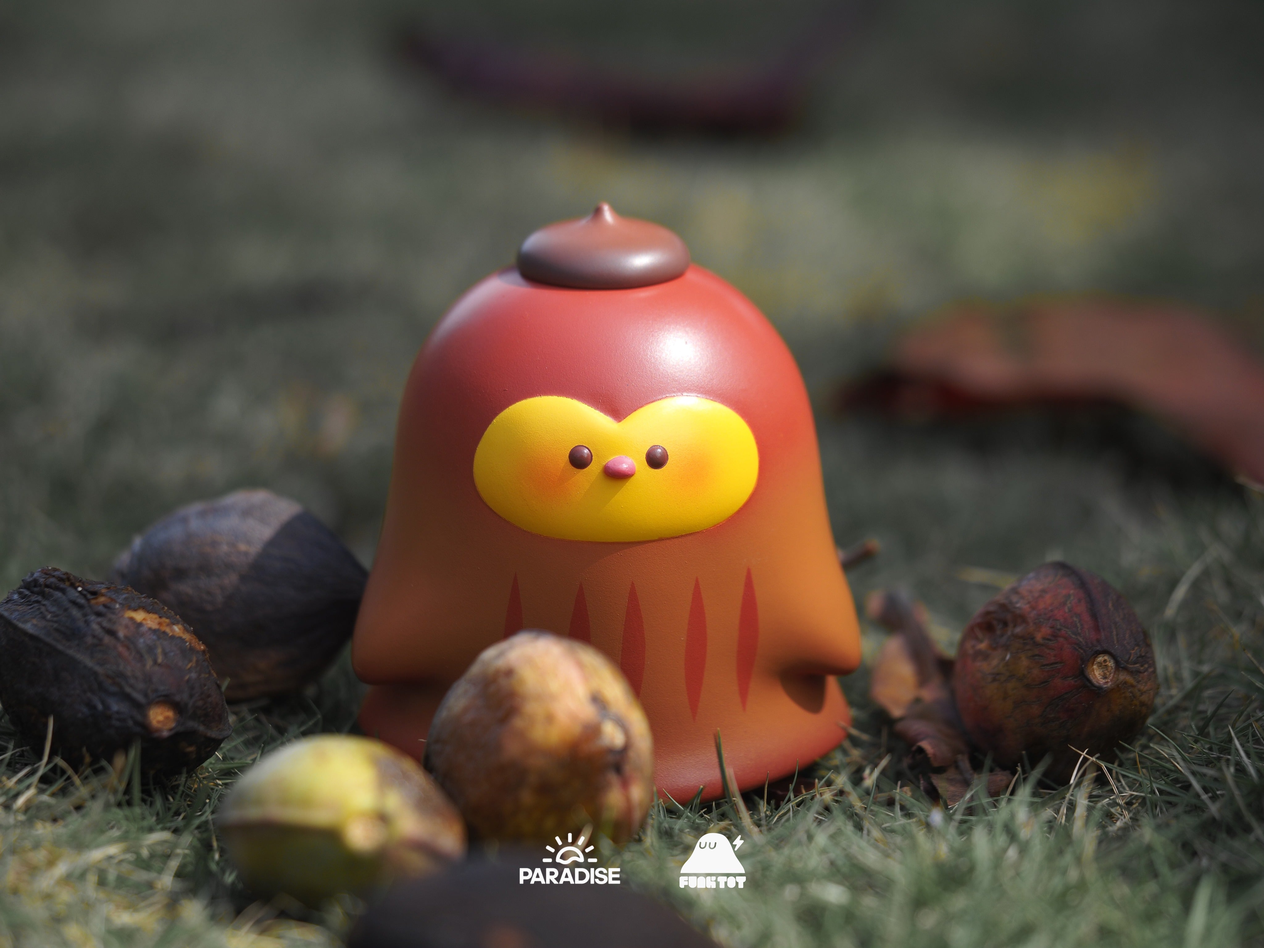 Fatty Penguin toy in grass, with yellow face and red accents, 8cm height, soft vinyl material.