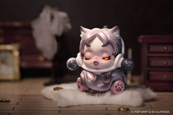 Toy figurine of a cat from The Mare of Animals by Skull Panda Blind Box Series on a white fur rug.