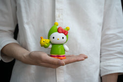 Hello Kitty RMX 2021 Project - Hello Kitty x GREENIE V2: Person holding toy figurine of cartoon character.