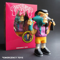 Toy figure with spray gun in mouth, pink box with toy figure holding spray can. Close-up of logo. Limited edition SPRAYED FIRST EDITION by EMERGENCY TOYS.